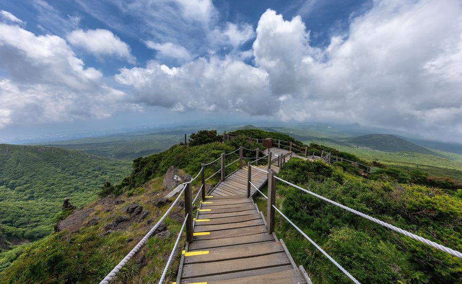 Деревянная лестница на тропе Yeongsil Trail с горами Халласан на Чеджу