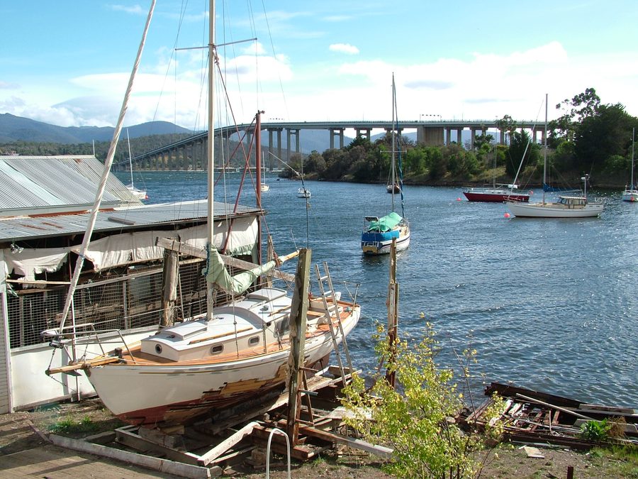 Вид на Montagu Bay в Тасмании с яхтой на сухом доке и мостом Tasman Bridge на заднем плане