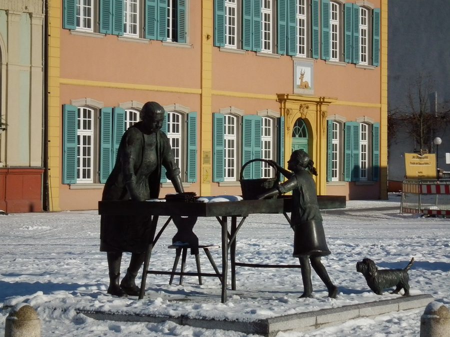 Женщина со спаржей на дворцовой площади Шветцингена на фоне дворца Хирш